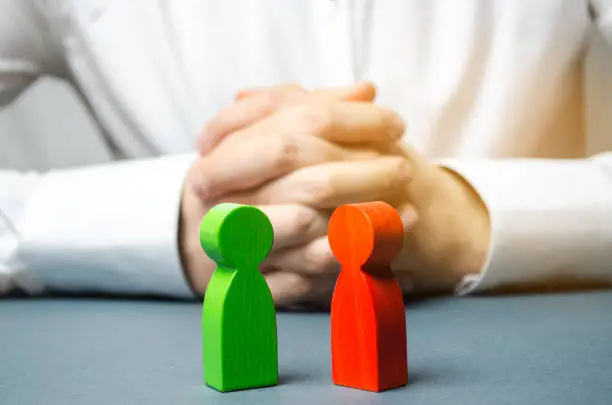 ACAS two wooden human figures, red and green, signifying employee dispute